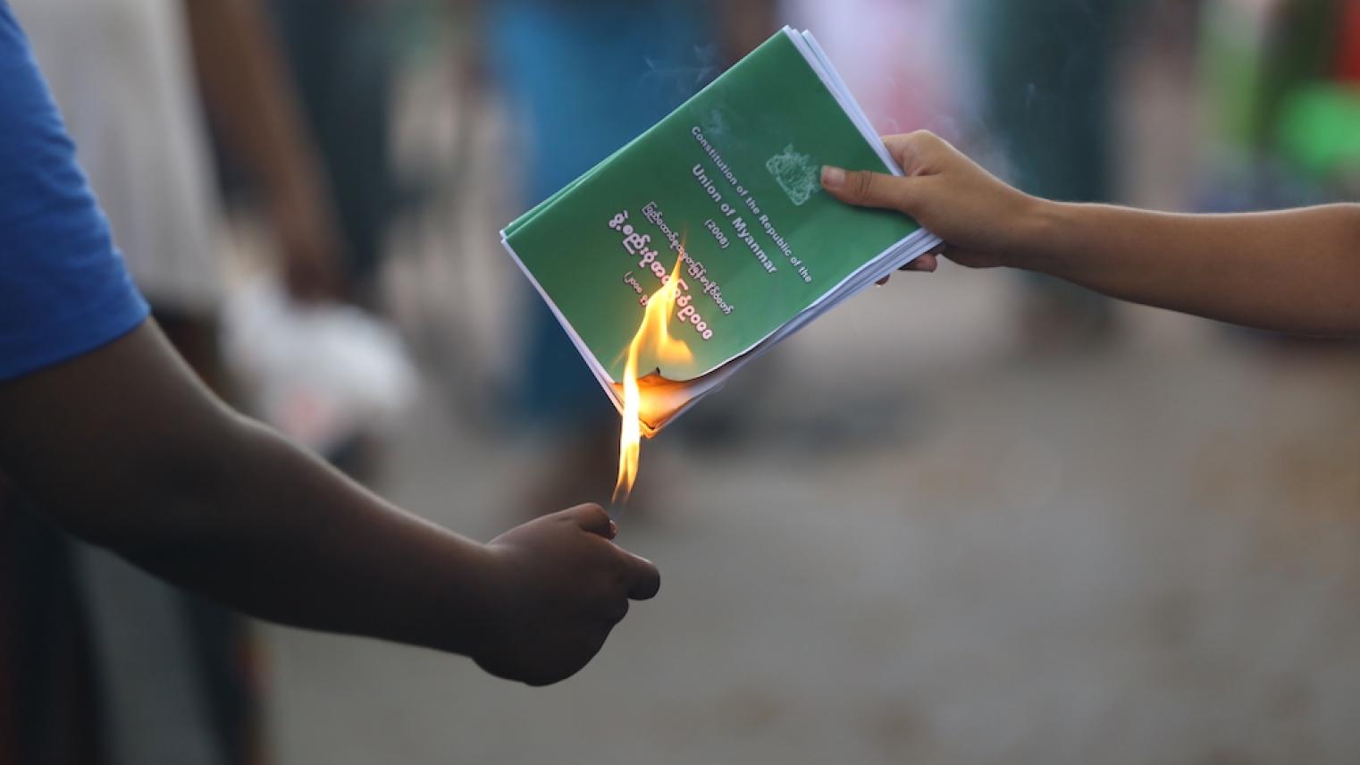 A man burning the 2008 Myanmar Constitution